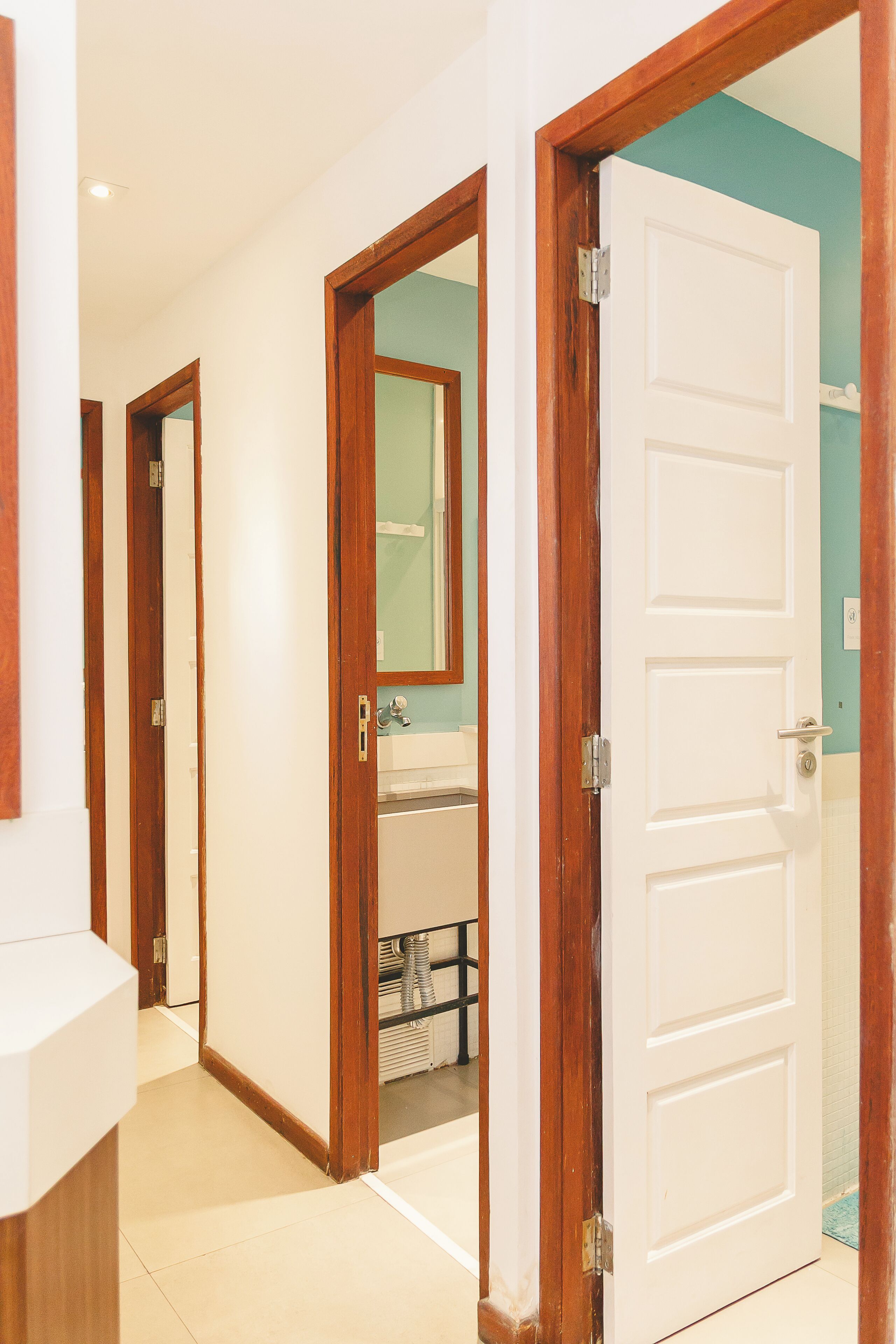 Un pasillo con puertas de madera que dan a un baño.