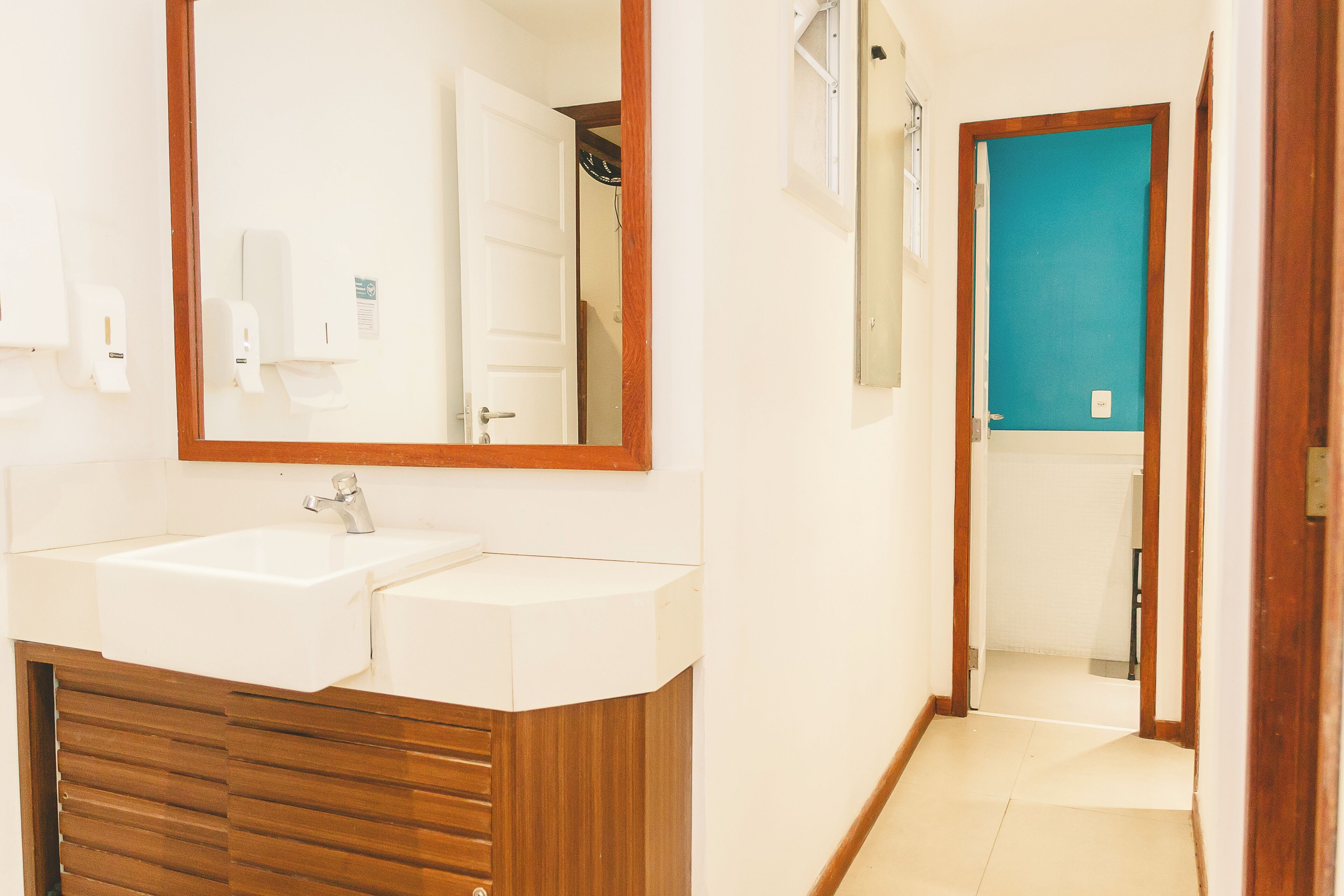 A bathroom with a double sink, wooden vanity, and a mirror.