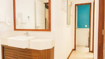 A bathroom with a double sink, wooden vanity, and a mirror.
