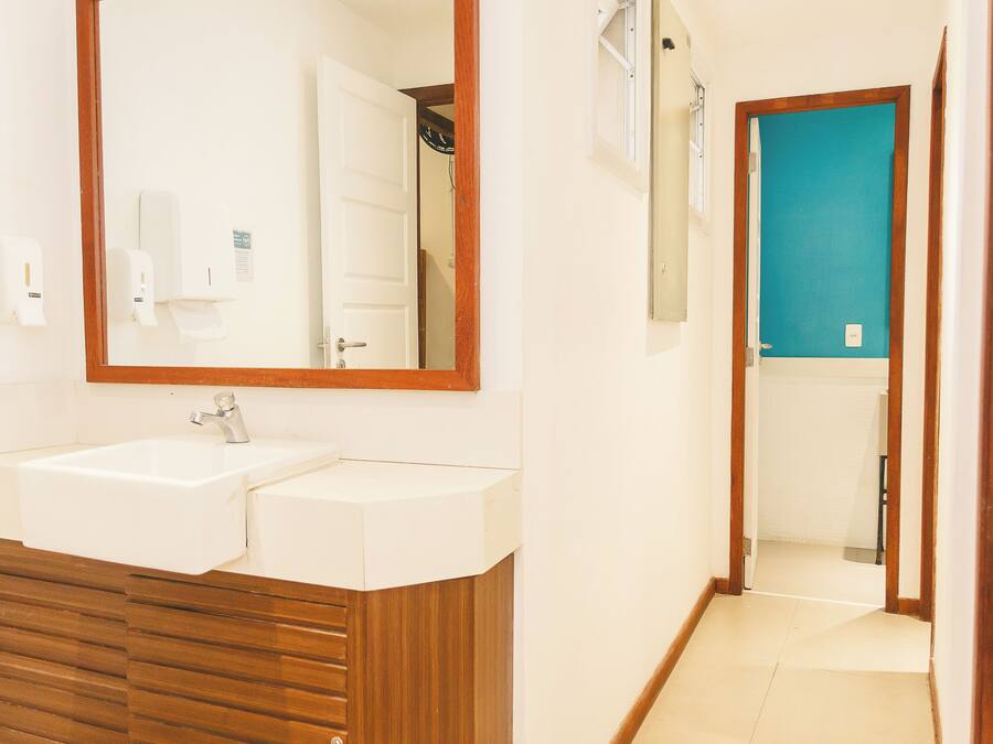A bathroom with a double sink, wooden vanity, and a mirror.