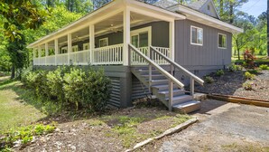 A small, single-story house with a porch and a staircase leading to the entrance.