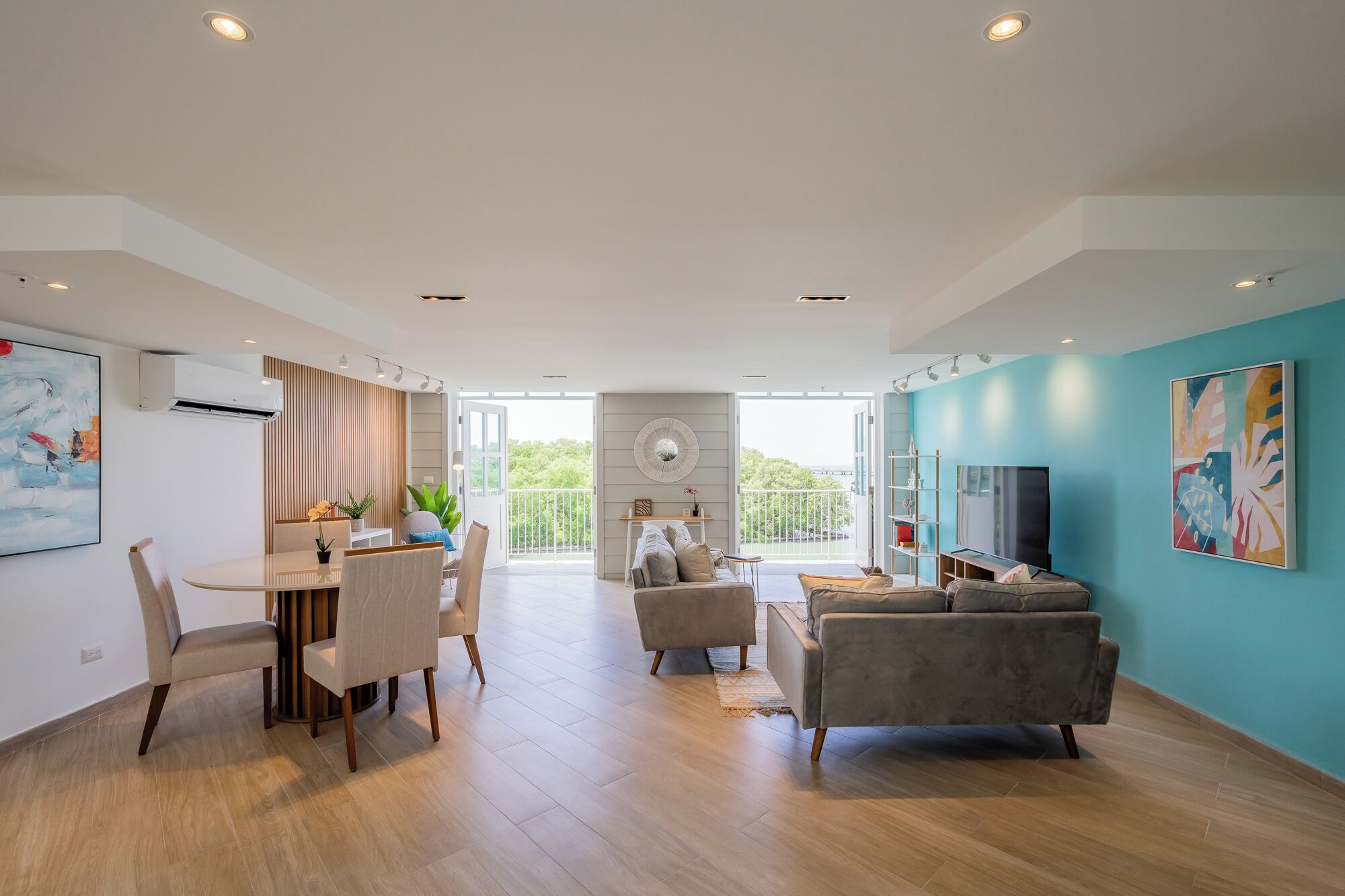 A spacious living area with a dining set, a sofa, and a TV.