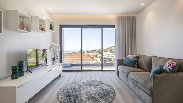 A modern living room with a sofa, TV, and decorative items. - Contemporary Residence B by Homie (Funchal)