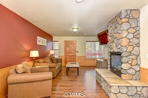 Smart-tv, eldstad, ett bordtennisbord och böcker