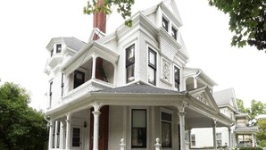 A large, white, two-story house with a prominent front porch and multiple windows. - Spectacular Queen Anne Victorian (Auburn)
