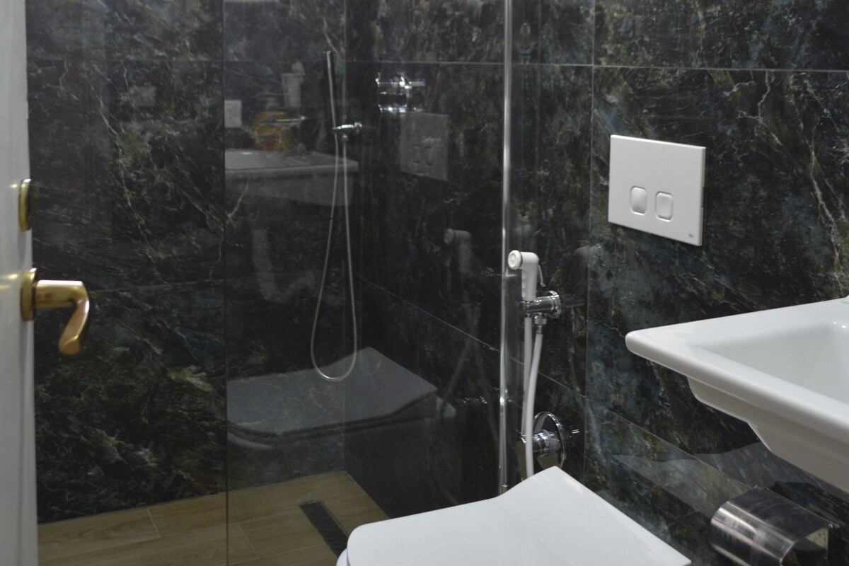 Une salle de bain avec une douche à parois de verre, des toilettes blanches et un lavabo.