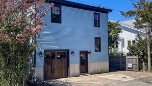A two-story house with a garage, a front porch, and a wooden fence. - 905 Page Street Cape May (Cape May)