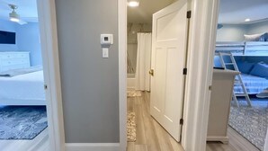 A bedroom with a bunk bed, a walk-in closet, and a bathroom with a shower curtain. - 905 Page Street Cape May (Cape May)