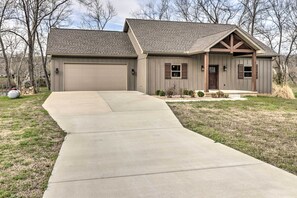 A two-story house with a garage, a covered front porch, and a concrete driveway.