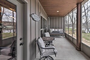 A covered porch with a seating area, including a table and chairs, and a sign that reads "WELCOME TO OUR PORCH".