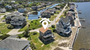 An aerial view of a residential area with houses, a dock, and a body of water.