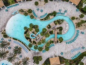 An aerial view of a resort with a large central pool, multiple lounge areas, and surrounding greenery. - Disney-Themed Family Retreat: Private Arcade & Pool w/Free Waterpark & Clubhouse (Four Corners)