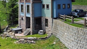 Ein mehrgeschossiges Haus mit einer Stein-Fassade, mehreren Balkonen und einer kleinen Außen-Sitzgelegenheit.