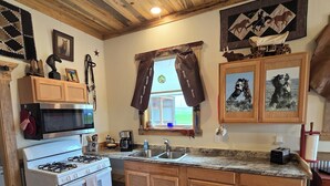 Une cuisine avec des meubles de rangement en bois, une cuisinière et un évier.