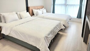 A hotel room with two beds, a wooden headboard, and a large window with curtains. - Grandbleu Hotel & Residence (Incheon)