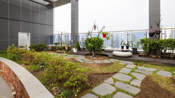 A rooftop garden with potted plants, a seating area, and a view of the cityscape. - Grandbleu Hotel & Residence (Incheon)