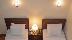 Two twin beds with white linens and towels, wooden headboards, and bedside lamps. - City center hotel Cairo  (Cairo)
