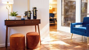 Uma sala de estar moderna com um sofá azul, uma mesa de centro de madeira e uma janela grande.
