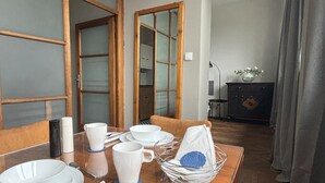 A dining area with a wooden table set for four, including plates, cups, and cutlery.