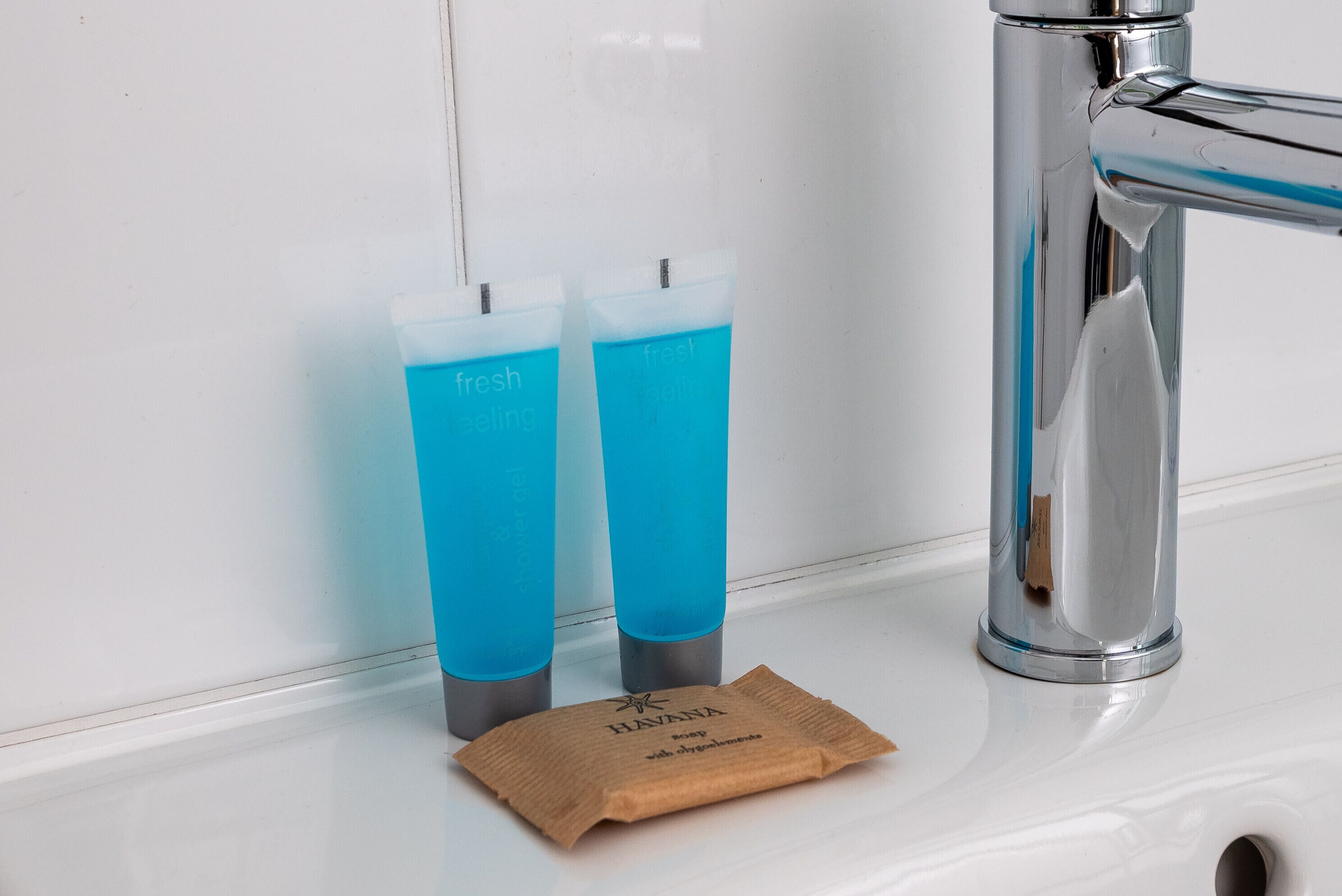 Two blue tubes labeled "fresh feeling" next to a faucet on a white sink.