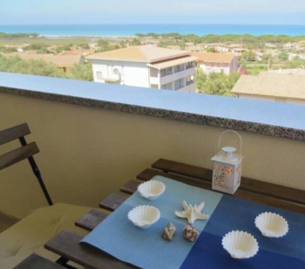 A balcony with a table, chairs, and decorative items. - Holiday Home 'Casa Vacanza Sa Petra Ruja B' with Sea View, Balcony and Air Conditioning (Siniscola)
