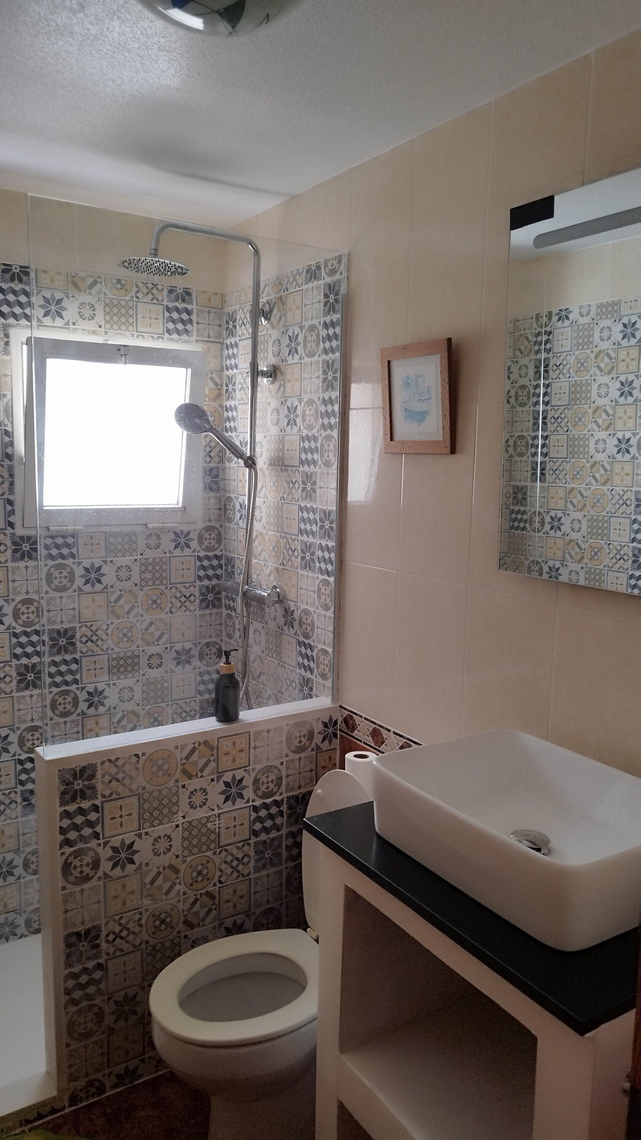A bathroom with a shower, toilet, and sink.