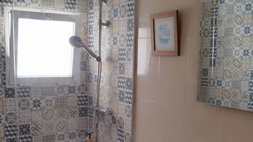 A bathroom with a shower, toilet, and sink.
