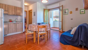 A compact living space with a kitchen, dining area, and a bed. - Apartment 'Casa Sara Lu Bagnu' with Private Terrace and Balcony (Lu Bagnu)