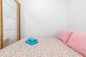 Un dormitorio con una cama, un armario de madera y un espejo.
