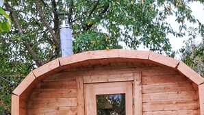 A wooden cabin with a door and window, surrounded by grass and trees. - Kranich by Interhome (Lübz)
