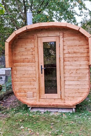 A wooden cabin with a door and window, surrounded by grass and trees. - Kranich by Interhome (Lübz)