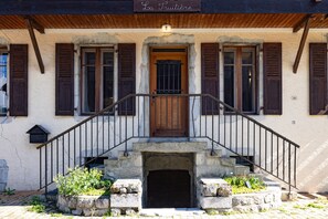 A building with a wooden door, stone steps, and a sign reading 'La Fruitiere.' - Apartment 'Ancienne Fruitière - Immoclean' with Mountain View, Private Terrace and Wi-Fi (Samoëns)