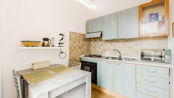 A compact kitchen with a gas stove, microwave, and a small sink.