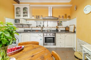 A kitchen with white cabinets, a stainless steel oven, and a microwave. - Los Aperos – Vacation Home for 10, Ciudad Real, Private Garden (Santibáñez de Valcorba)
