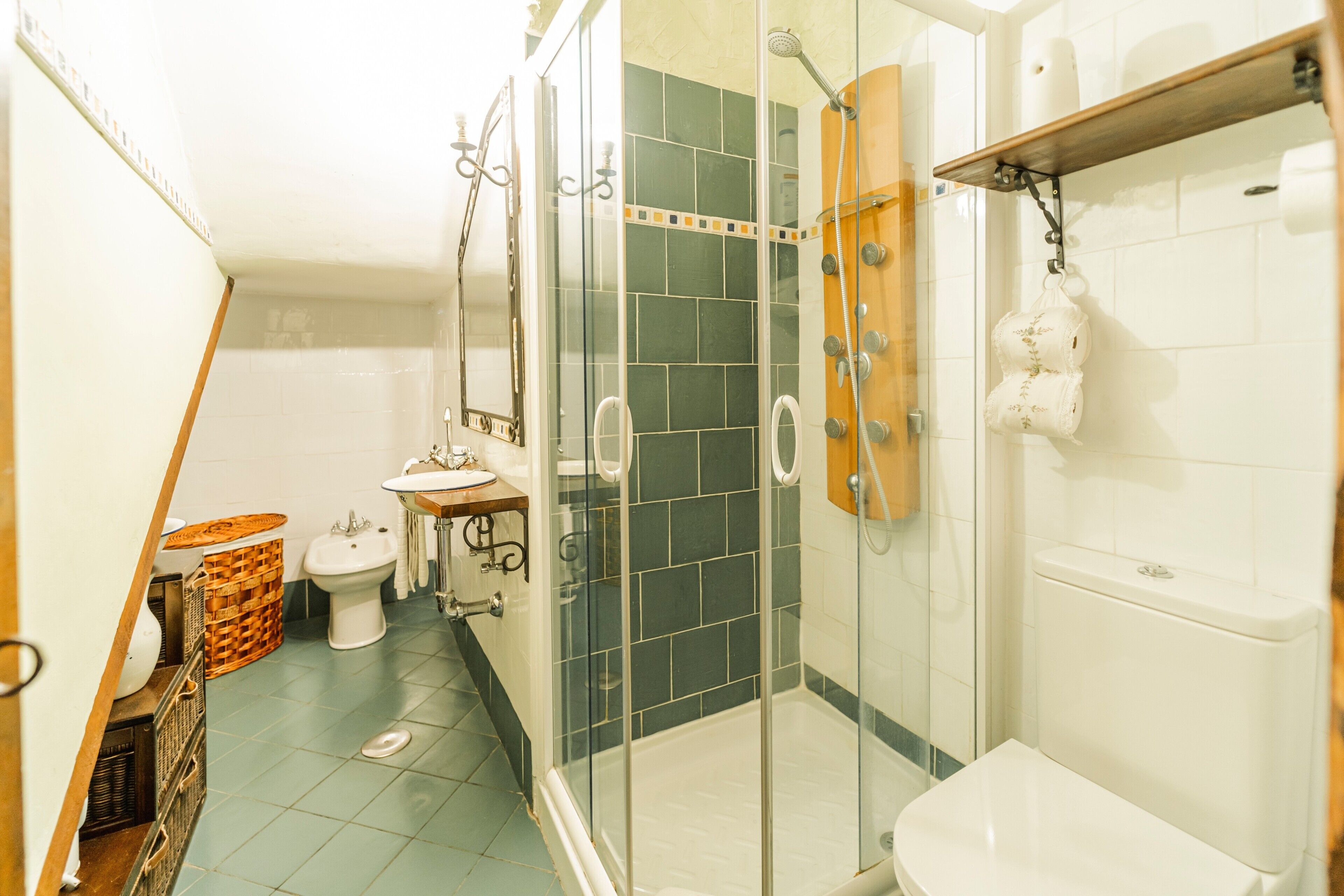 A bathroom with a glass-enclosed shower, a toilet, and a sink.