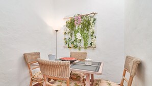 Ein Essbereich mit Korbstühlen, einem Tisch und einer Wanddekoration mit Blumen.