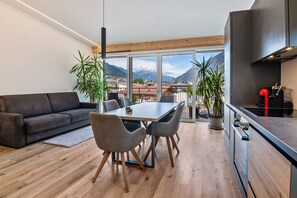 Un salon moderne comprenant un canapé, une table à manger, des chaises et un coin cuisine.