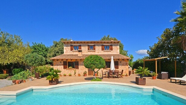 A two-story stone house with a swimming pool in front. - Villa 'Carbonell' with Mountain View, Wi-Fi and Air Conditioning (Alcudia)