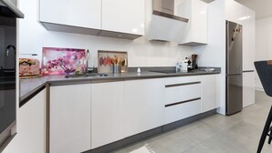 A modern kitchen with white cabinets, stainless steel appliances, and a grey countertop. - Apartment 'Apartamento Novasol' with Private Terrace, Wi-Fi and Air Conditioning (Fuengirola)