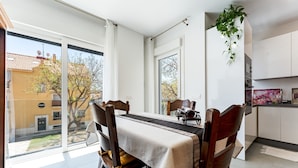 A dining area with a table set for four, a view of the outside, and a kitchen area with cabinets and a countertop. - Apartment 'Apartamento Novasol' with Private Terrace, Wi-Fi and Air Conditioning (Fuengirola)