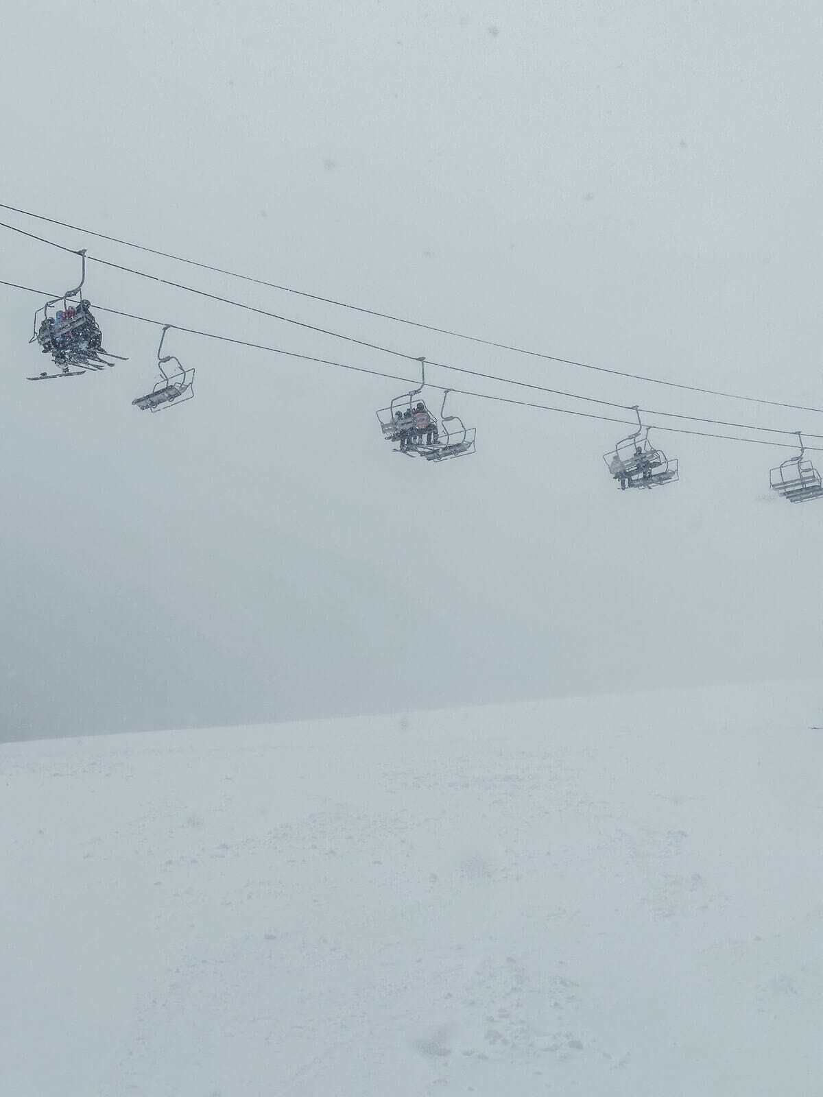 Un télésiège composé de plusieurs chaises suspendues à des câbles.