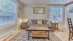 A living room with a sofa, coffee table, and two side tables.