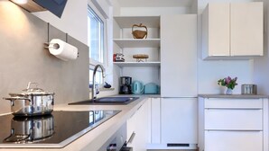 A modern kitchen with a stove, sink, and white cabinets. - Vacation home Eja by Interhome (Buje/Plovanija)