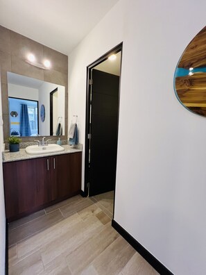 Bathroom features a large mirror, two sinks, and a bathtub.