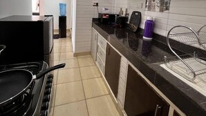 Uma cozinha compacta com fogão, armários e bancada.