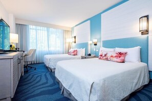 Een hotelkamer met twee bedden, een bureau en een stoel.