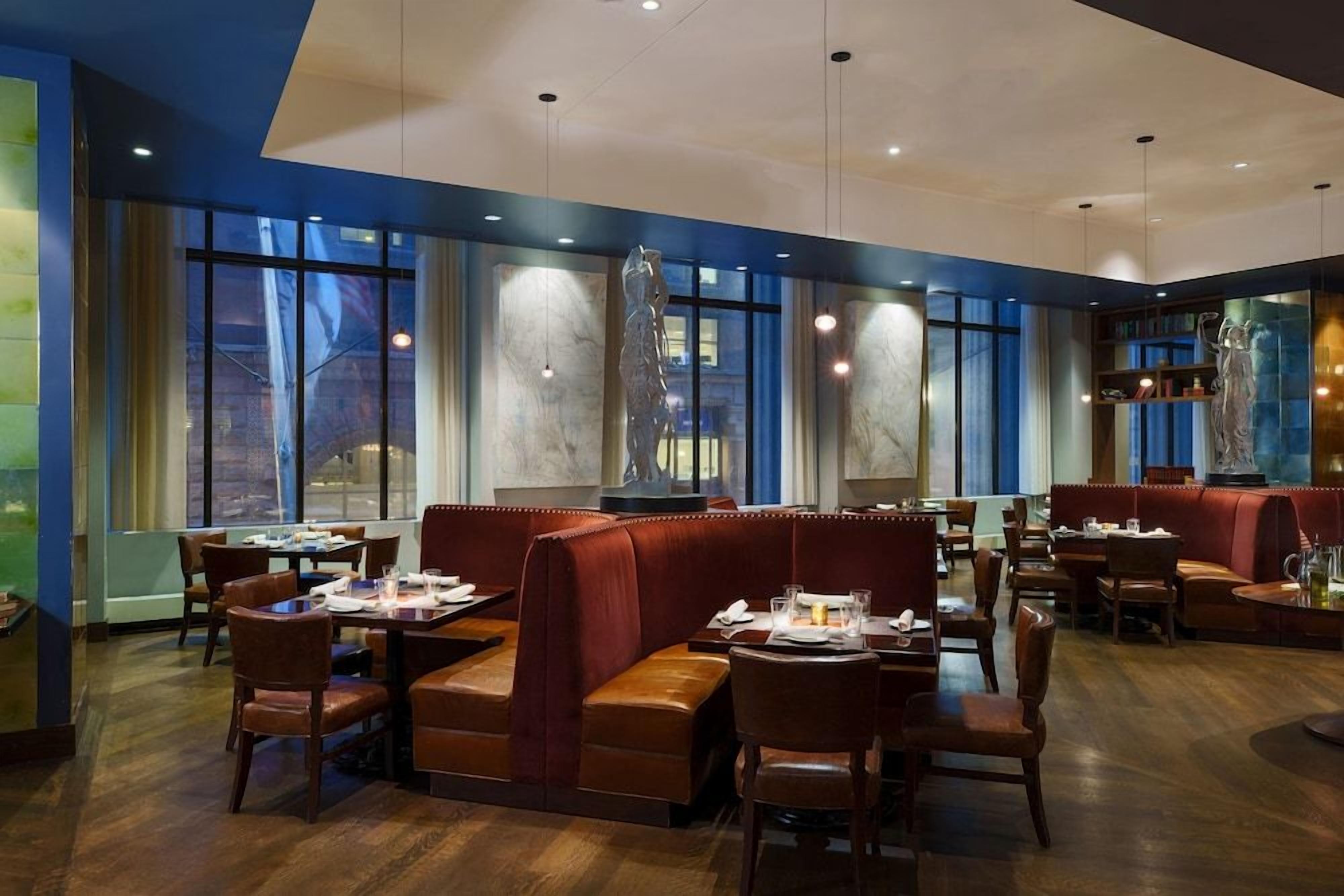 A restaurant with booths, tables, and a marble wall.