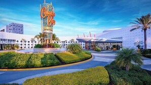 A hotel with a prominent tower sign, a modern building with a unique circular design, and well-maintained landscaping. - 1-Bedroom Suite at a  Hotel (Orlando)