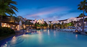 A resort with a large pool, palm trees, and a building with multiple balconies. - 2-Bedroom Suite at a 4⭐️ Hotel (Orlando)