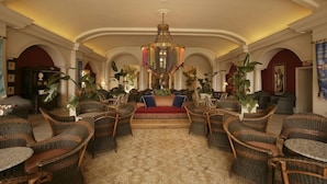 A spacious lobby with a central seating area, high ceilings, and a chandelier. - 2-Bedroom Suite at a 4⭐️ Hotel (Orlando)